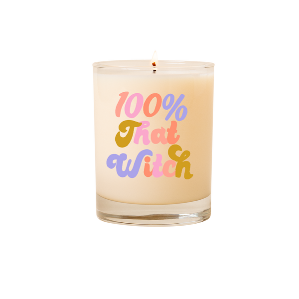 Candle rocks glass with text that reads "100% That Witch" in multicolor font on front of glass