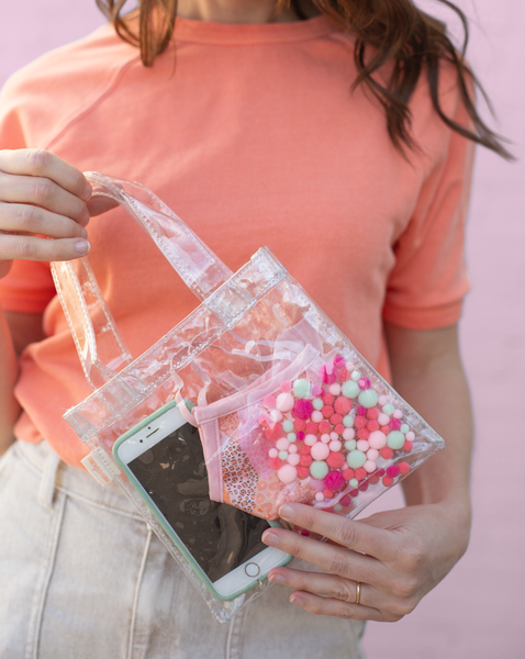Girl holding a cute tiny bag in clear vinyl with colorful 