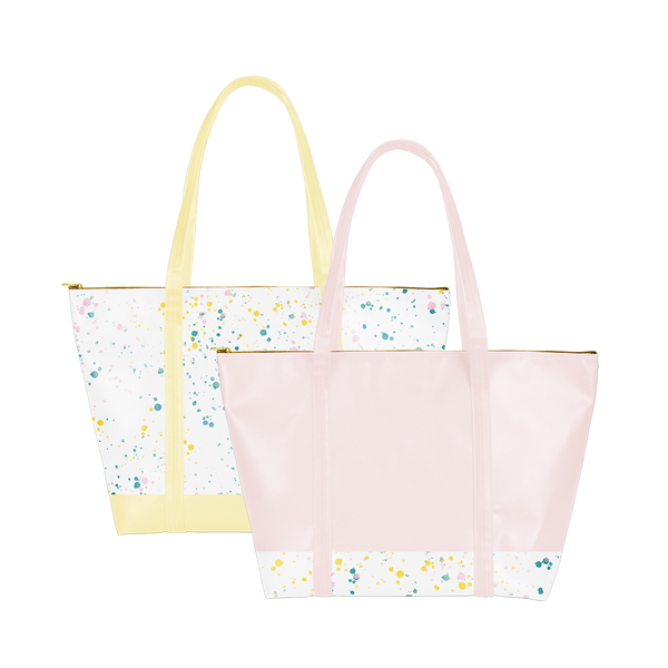 two vegan leather weekend bags. one with yellow straps and splatter all over. one pink with splatter on the bottom