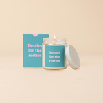 A 8 oz. candle jar with lid, with a teal decal on it "Besties for the resties" printed on.