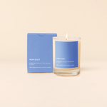 14 oz candle rocks glass with blue decal and text that reads "MOM GUILT; smells like: damned if I do, damned if I don't; with notes of: black currant + amber" in white font. Blue box packaging with the same design sits behind the candle.