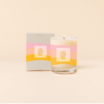 Rocks candle reading "LET THAT SHIT GO" in front of tri-color horizontal stripes around candle. Box packaging with same design and text as candle.