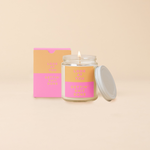 An 8 oz. candle w/ a lid and a split-colored decal (Orange and Pink) and the phrase "Look at you gettin' shit done" printed on.