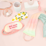 a pastel neck wrap, lemons weighted eye mask, and a pastel sleep mask on a pink background