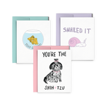 Three letterpress greeting cards stacked, one has a goldfish in a fishbowl and says Stay Golden, one has a purple snail and says Snailed It, and one has a doodle of a dog and says You're The Shih Tzu.