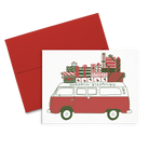 greeting card with a red and white van the top covered in christmas present, 'seasons greetings' written on the top. 