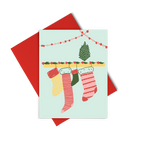 a greeting card with a drawing of four different size Christmas stockings hanging on a ledge with tinsel.