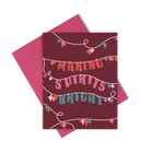A dark red greeting card with string lights in teal, pinks, and red, and "making spirits bright"