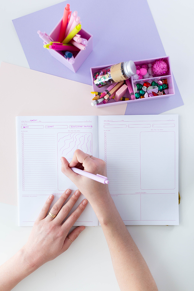 A two page spread with a to-do section, a drawing section, and a notes section. Pages are white with pink lining and is being written on with a Blush Pink Jotter Pen. It is also displayed with a lilac desk set and other colored Jotters and stationary items.