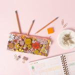 Flower Power Pencil Kit with pencils, paper clips, a planner and eraser laying on a pink desk.