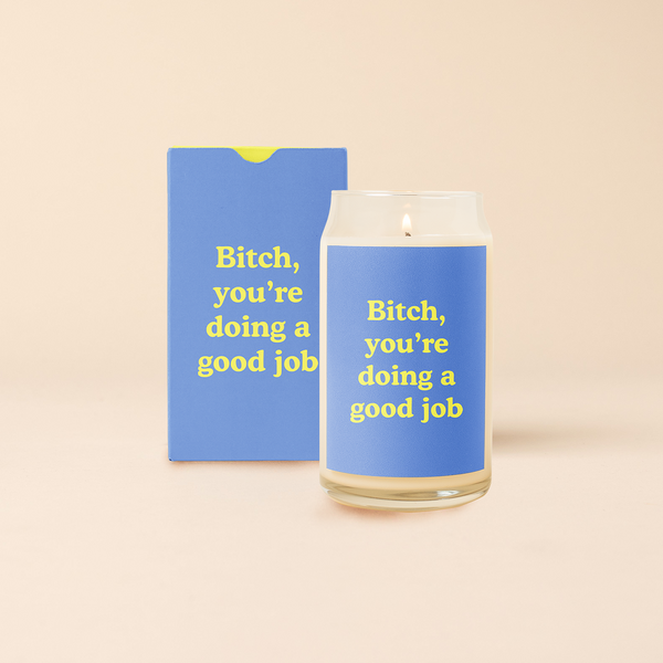 16 oz candle can glass with blue decal and text that reads "Bitch, you're doing a good job" in lime green colored font. Blue box with same design sits behind candle.