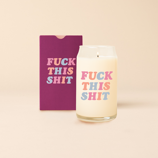 Can glass candle with text that reads "FUCK THIS SHIT" in multi-color font, Box packaging with same design sits behind candle.