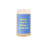 A 16 oz. candle with a blue decal on it with the phrase "Bitch, you're doing a good job" printed on.