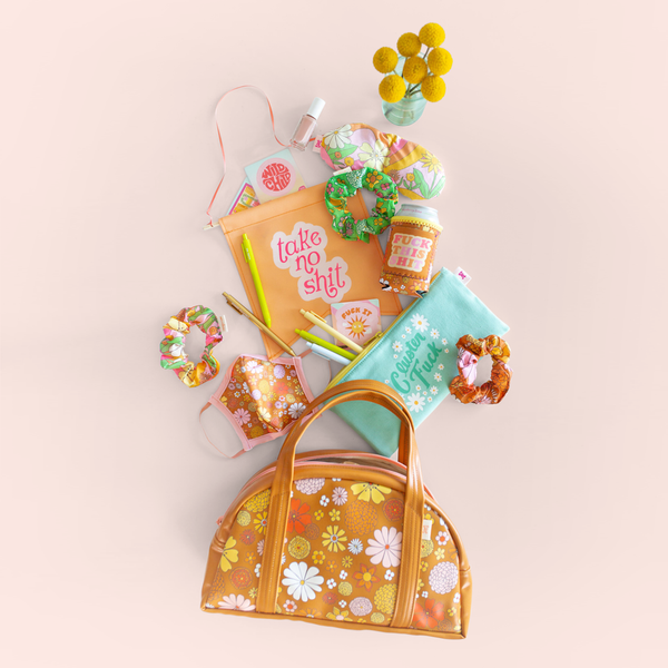 group of flowered gift items spilling out of a floral bag with sayings "take no shit", "cluster fuck" and "fuck this shit"