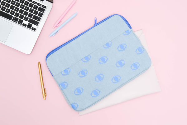 Eyeballs Canvas Laptop Sleeve is a cute laptop sleeve in light denim with eyeballs pattern in 13 inch size next to a macbook and jotters
