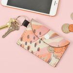 A small coin purse sits with keys, a phone and loose change.