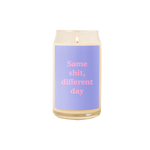 A 16 oz. candle with a light blue decal on it with the phrase "Same shit, different day" printed on.