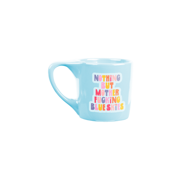 Bright blue coffee mug with colorful saying "nothing but mother fucking blue skies"
