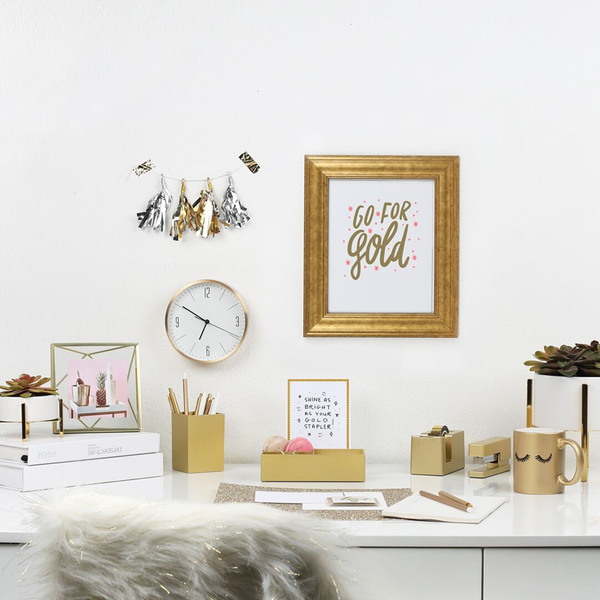 A office scene with a gold frame on the wall. The frame contained a gold and pint print with the text "Go For Gold"