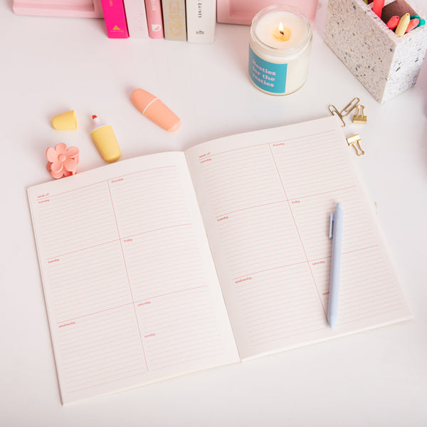 Weekdays planner with Powder Blue jotter pen, teal and pink besties for the resties jar candle, yellow and peach pastel highlighter.