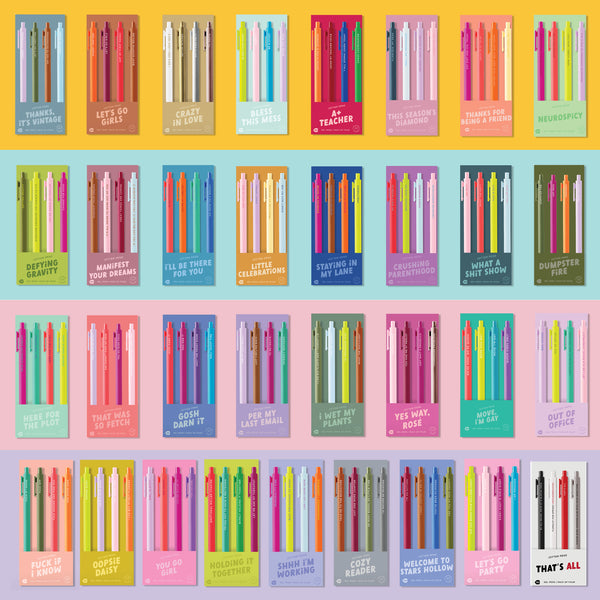 Colorful novelty pen sets with humorous and sassy phrases on packaging, such as 'Bless This Mess,' 'Let’s Go Party,' 'Move, I’m Gay,' 'Per My Last Email,' and 'I Wet My Plants.' Each set features vibrant pen colors and playful fonts, displayed in a grid layout on pastel backgrounds—perfect for gift ideas, stationery lovers, or office desk accessories.