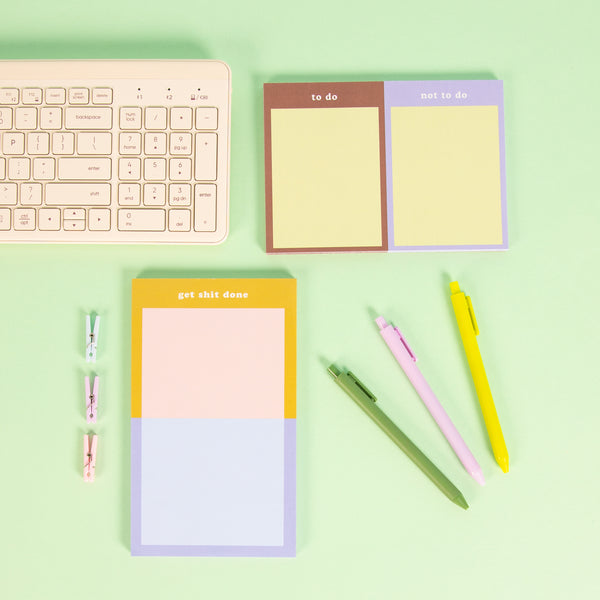 Tearaway notepads with misc items on a pastel green background. 