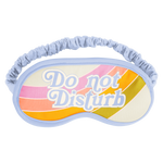 Blue bordered sleep mask with pink, pastel coral, orange, and green curved stripes that says "Do Not Disturb" on it. 