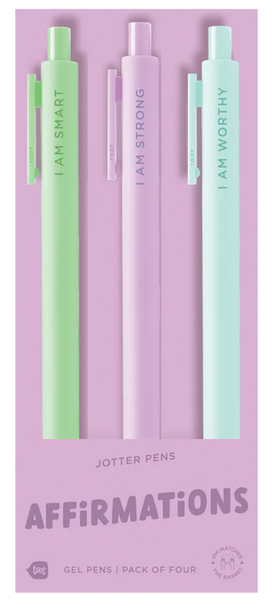 A pack of four pastel jotter pens displayed on lavender packaging. Each pen features a different affirmation: mint green says “I AM SMART,” light purple says “I AM STRONG,” and light aqua says “I AM WORTHY.” The fourth pen is mostly hidden. The bottom of the packaging reads “JOTTER PENS – AFFIRMATIONS – Gel Pens | Pack of Four.”