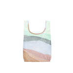 A Twist and Shout reusable tote in a watercolor pattern of browns, pinks, blues and white. This reusable tote is made with ripstop nylon and folds up into interior pocket to make a pouch you can take anywhere!!