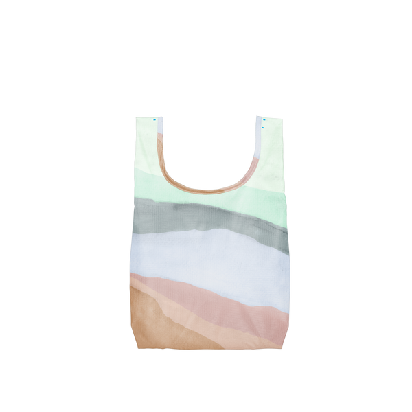 A Twist and Shout reusable tote in a watercolor pattern of browns, pinks, blues and white. This reusable tote is made with ripstop nylon and folds up into interior pocket to make a pouch you can take anywhere!!