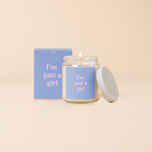 A Yippie Toot Candle Jar with Lid that says I'm just a girl in pink on a blue background with a matching box 