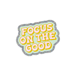 This sticker is scalloped shaped and sliver glitter boarder with a turquoise background. "FOCUS ON THE GOOD" is written in bold, retro style block letters. The text is written in light pink with a golden colored outline.