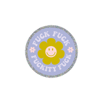 This is a round sticker with a silver glitter boarder. The background is lavender with a green smiley face flower in the center. The words "FUCK FUCK FUCKITY FUCK" are surrounding the green smiley face flower with two small daisy flowers are on either side of the center smiley face flower.