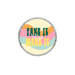 This a a round sticker with a silver glitter boarder. The background is wavy stripes in light yellow, pink, and turquoise. The text reads "FAKE IT" in hunter green, "til you" in white cursive and "MAKE IT" in yellow. 
