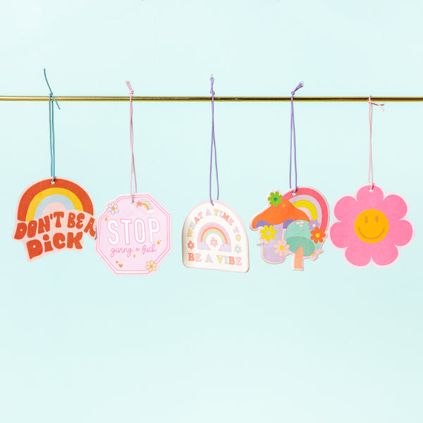 Five Talking Out Of Turn air fresheners with groovy and pastel colors displayed with a blue background.