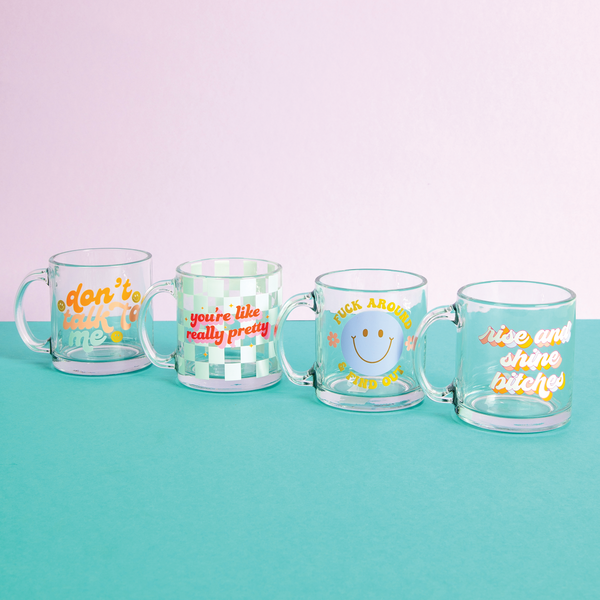 All new sassy glass mugs on a teal surface and a purple background