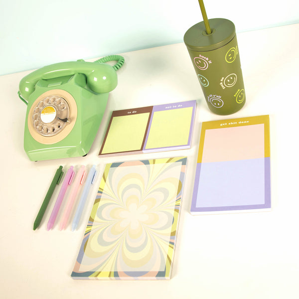 All tearaway notepads with "fuck off" cold cup and other misc items on a white surface
