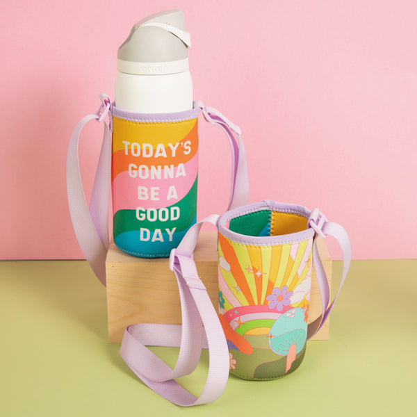 "Today's gonna be a good day" reversible simple hydration sling on a green surface and pink background.