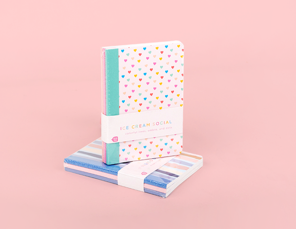 Mini notebooks. One with multicolored mini hearts, and the other with a lined design with pastel pinks, creams, and darker blues.