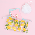 lemons jetsetter with makeup brushes inside laying on a pink background