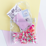 Cute tiny bag in clear vinyl with colorful pom poms 