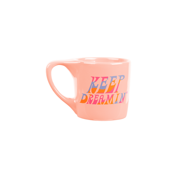 Peach mug which says keep dreamin'