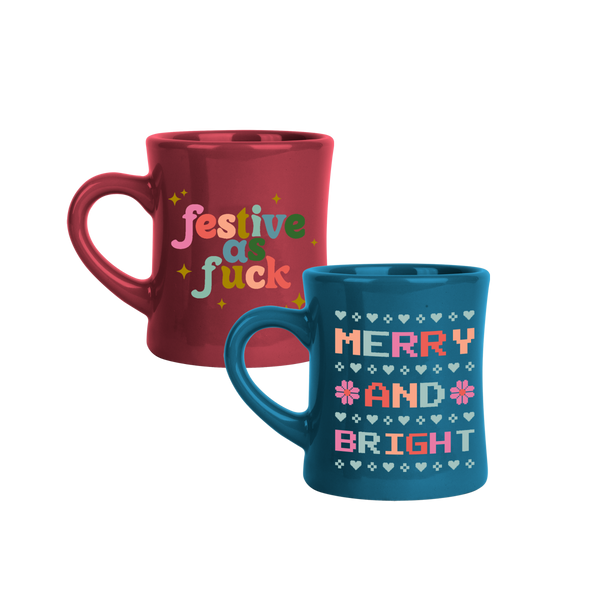 Red mug that says "Festive as fuck" in multicolors. Blue mug that says "Merry and Bright" in multicolors. 