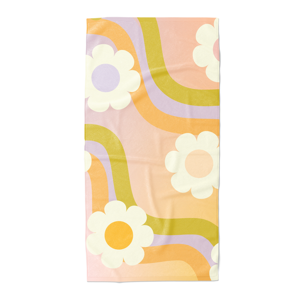 Beach towel with white daisies and a wavy groovy pattern in the colors orange, green, and purple.