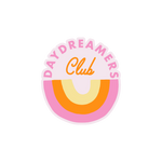 "Daydreaming Club" sticker with a upside down rainbow in the colors pink, orange, and yellow.
