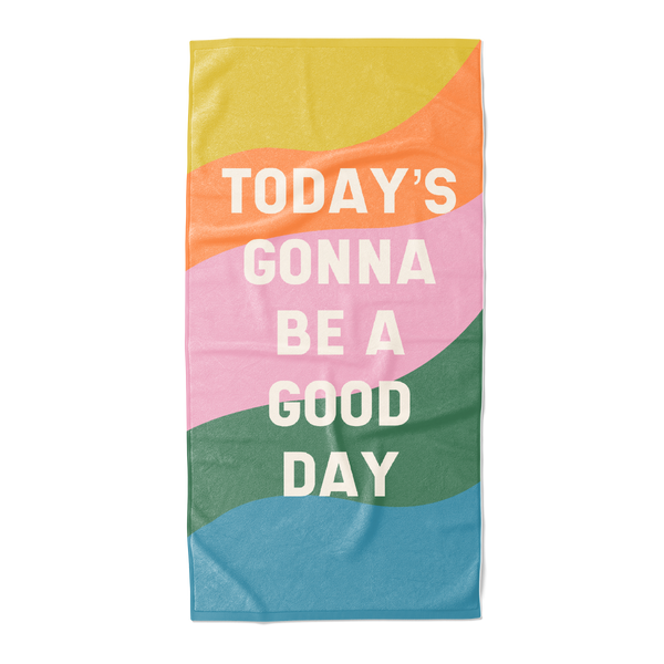 All caps "today's gonna be a good day" text with colorful wavy rainbow beach towel.