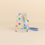 Clear vinyl bucket bag with multi-colored daisies wrapped around bag. White rope adjustable enclosure and blue adjustable shoulder strap.