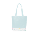 A cute tote bag with long shoulder strap in a powder blue with white paint splatter detail along the bottom.