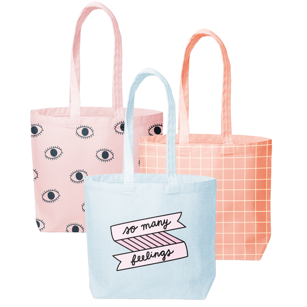 Three canvas tote bags; beachwash denim with so many feelings print, peach with grid pattern, and blush pink with eyeballs pattern.