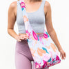 girl wearing a pale blue colored bagabond crossbody tote with cranberry, orange, teal and pink fall floral leaves